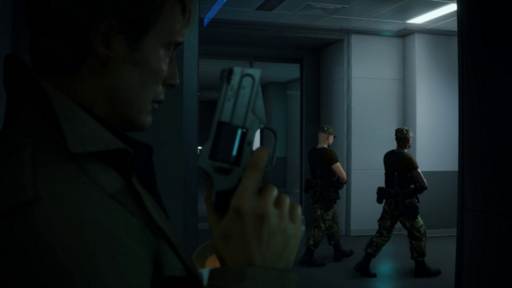 Death Stranding screen capture - Mads Mikkelsen's character leans against a wall holding a pistol