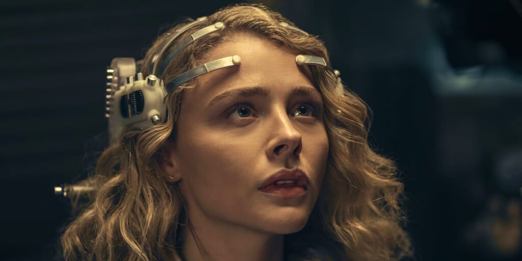 Screen from The Peripheral TV show. Close up of Chloë Grace Moretz as Flynne Fisher wearing the titular peripheral device.