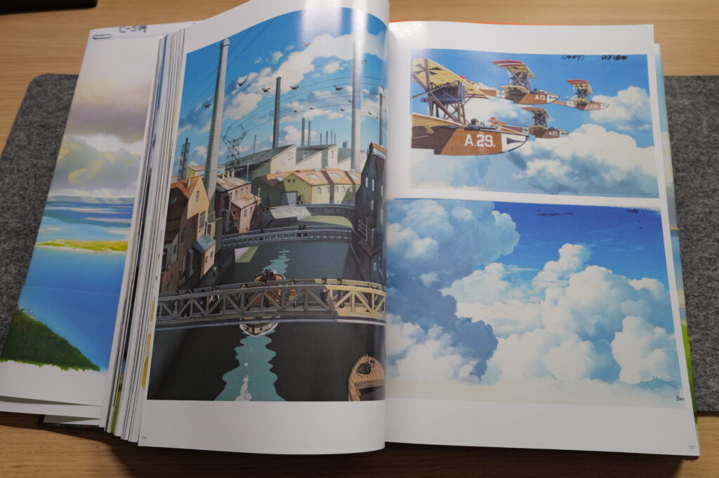 Photograph of a page from Painting the Worlds of Studio Ghibli book, featuring beautiful paintings from their animated films.