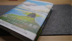 Photograph of book cover for Painting the Worlds of Studio Ghibli, on a desk at an angle.